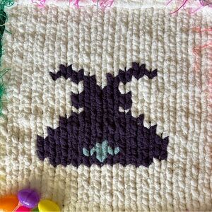 Handmade chunky knit cream coloured baby blanket with a purple bunny.